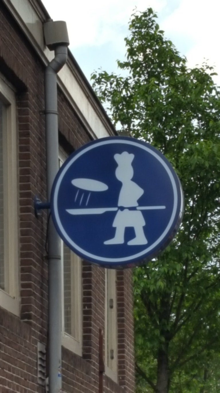Blue sign with person flipping a pancake in Amsterdam