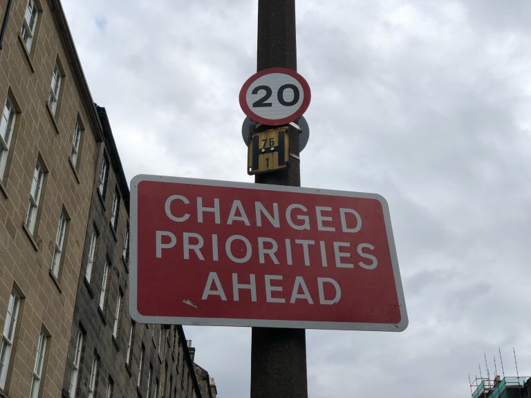 Changed priorities ahead road sign